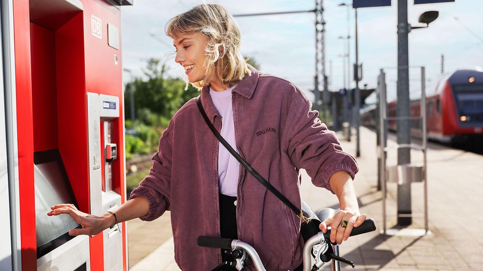 Frau bedient Ticketautomat