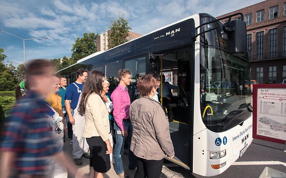Personen steigen in Bus ein